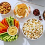 Seven guilt-free healthy desk snacks arranged on office desk for busy professionals seeking workplace wellness
