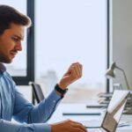 Person experiencing wrist pain from typing at computer workstation